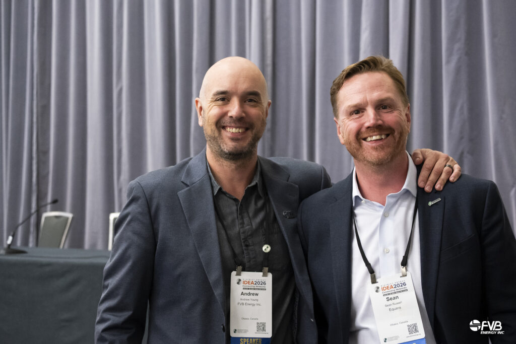 Two speakers posing together at IDEA2026, wearing conference badges and smiling in front of a presentation backdrop.