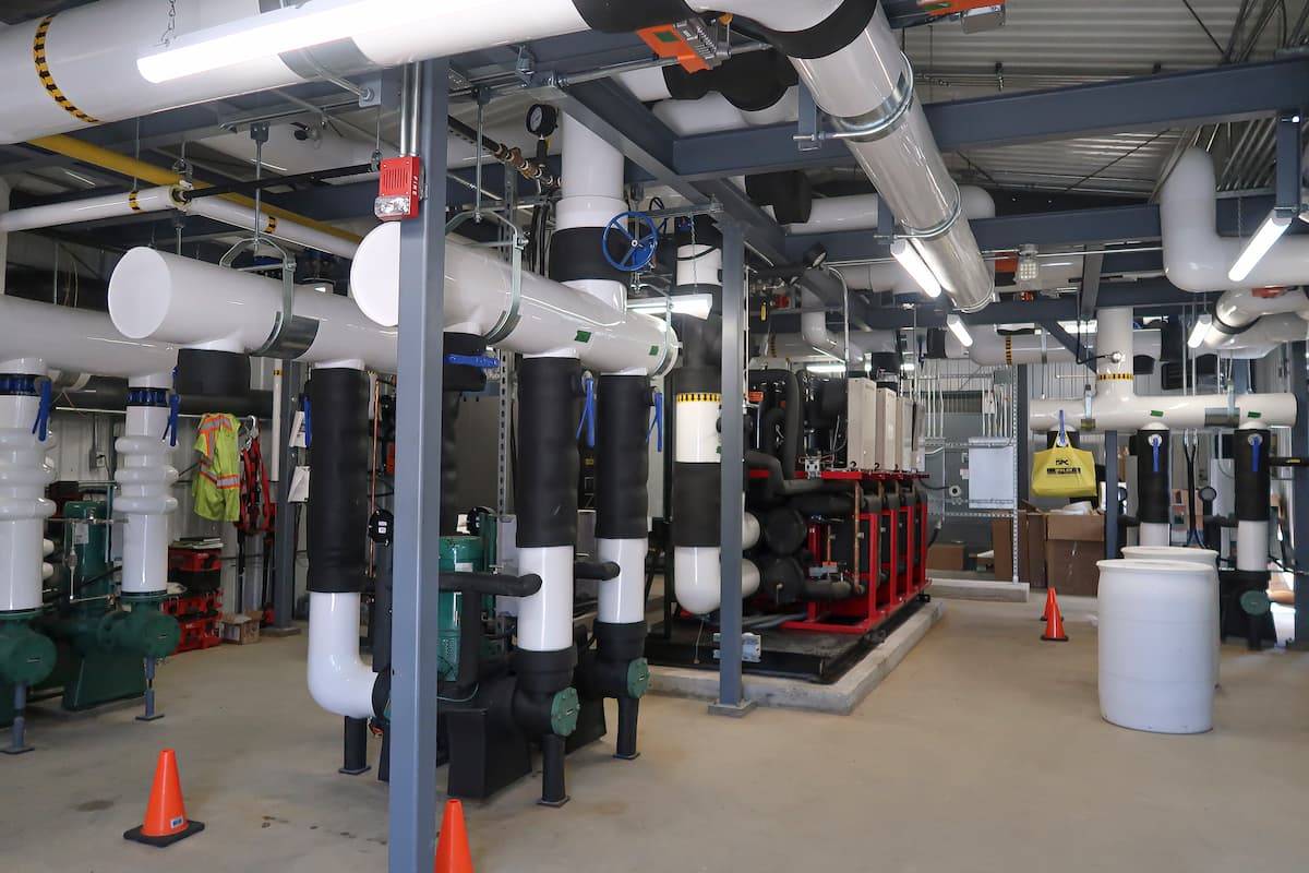 Mechanical piping, pumps, and energy transfer equipment inside the DND Green Heat district energy plant supporting low-carbon heating and building decarbonization.